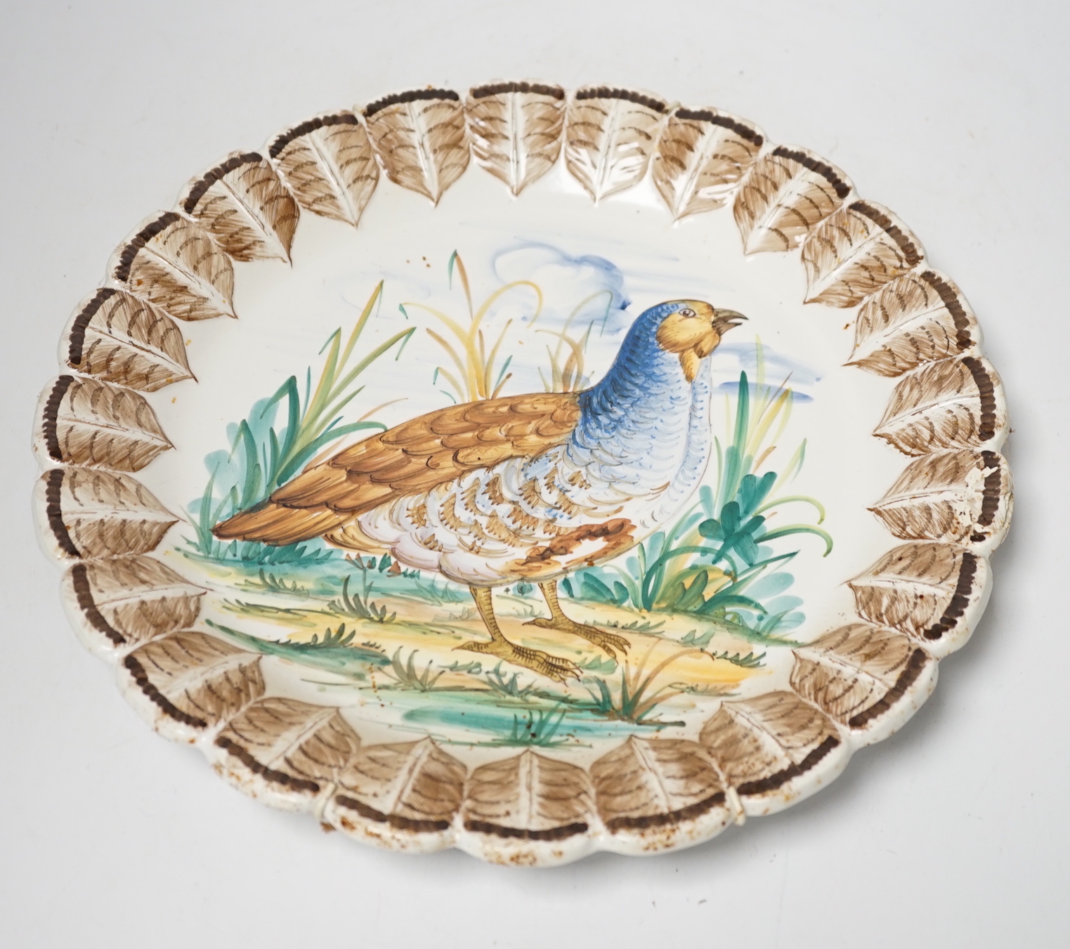 A set of Italian maiolica plates and serving dishes painted with central bird decoration within a painted feather border